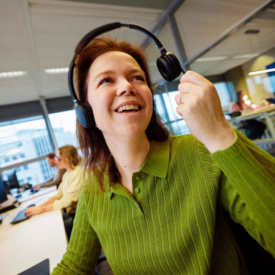 Medewerker van Zonneplan met headset aan de telefoon op kantoor