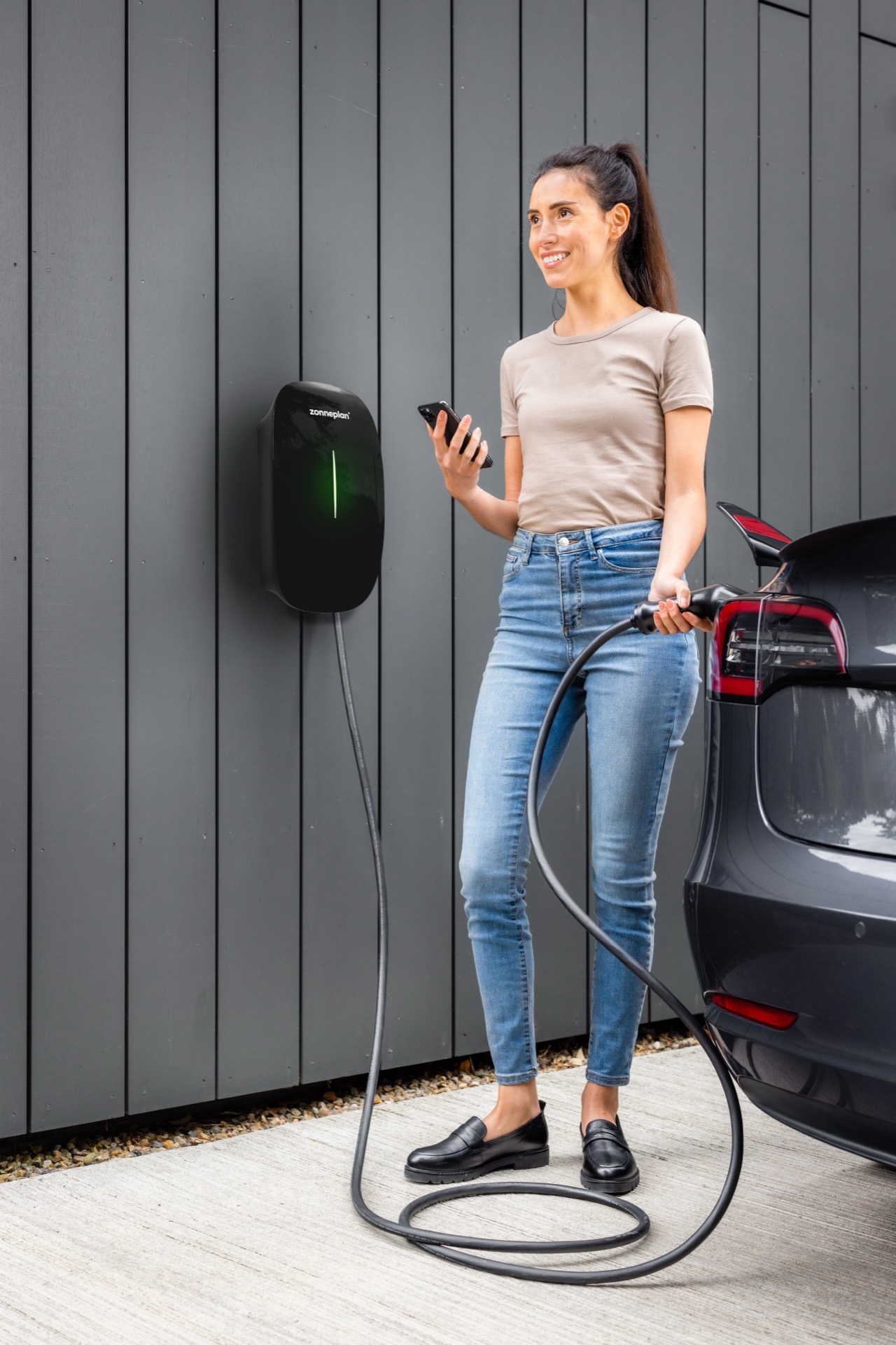 Vrouw laadt haar auto met de Zonneplan Charge 3
