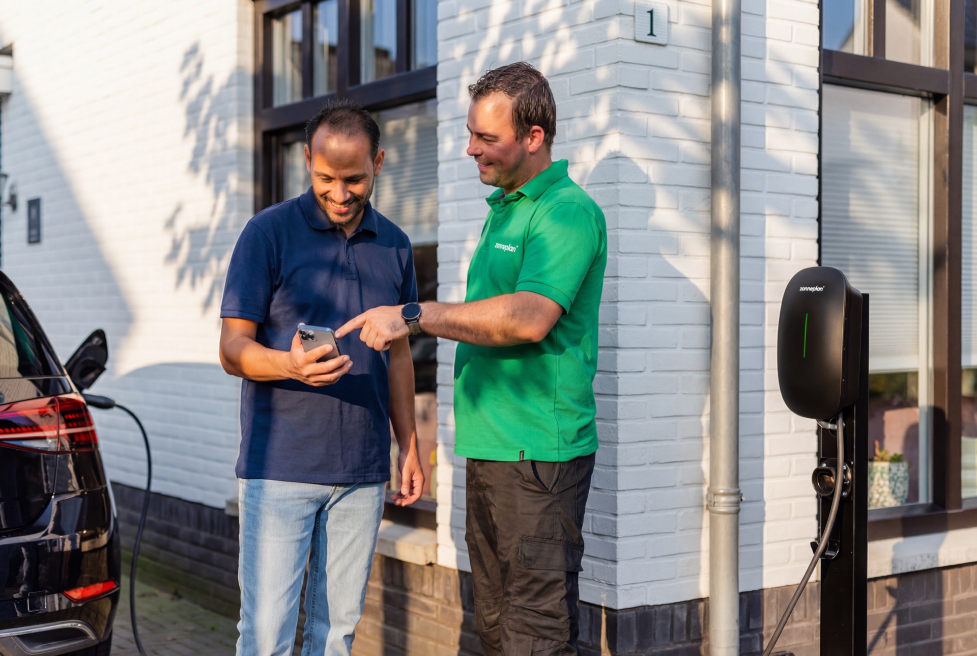 Zonneplan monteur met klant bij laadpaal installatie